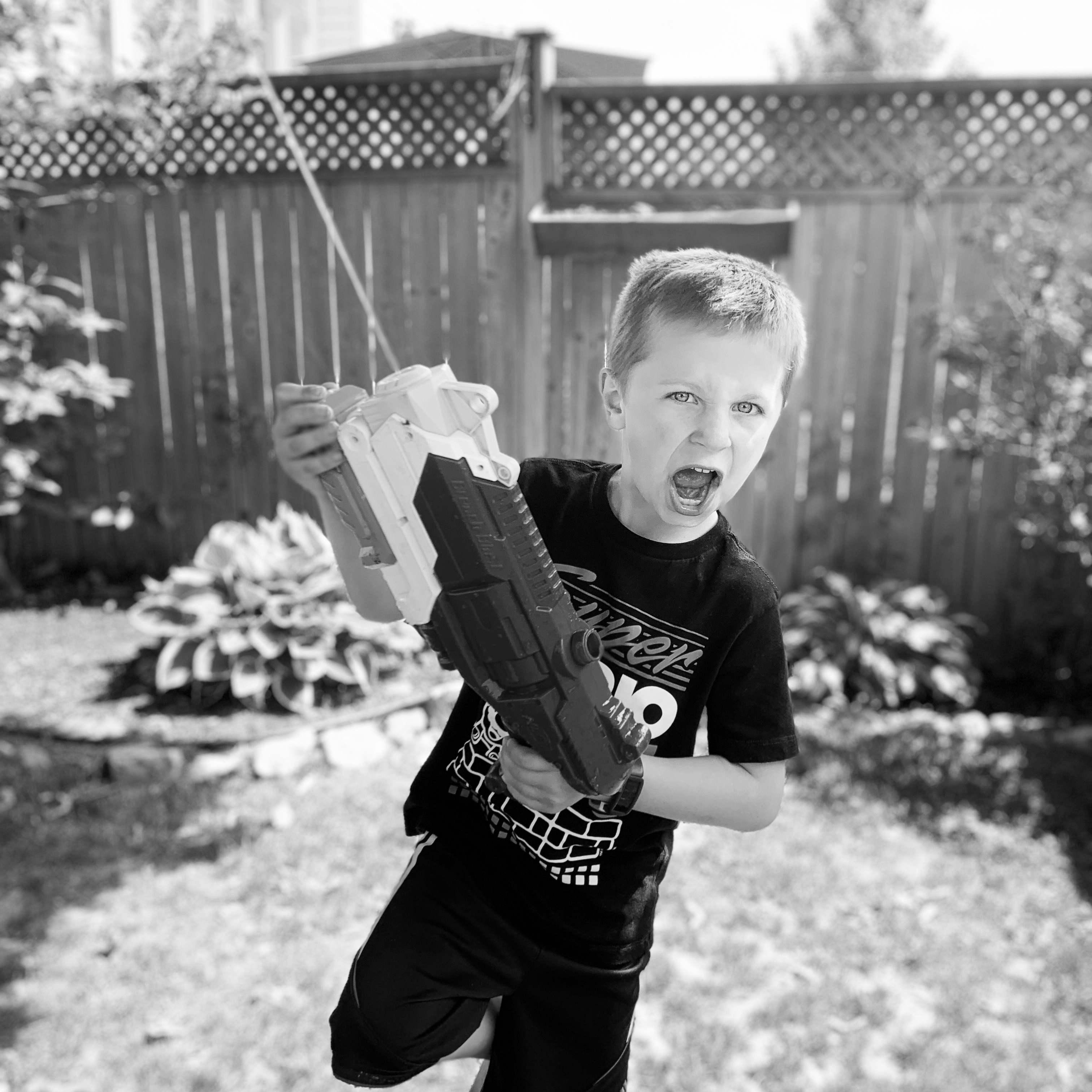 my boy playing with a watergun